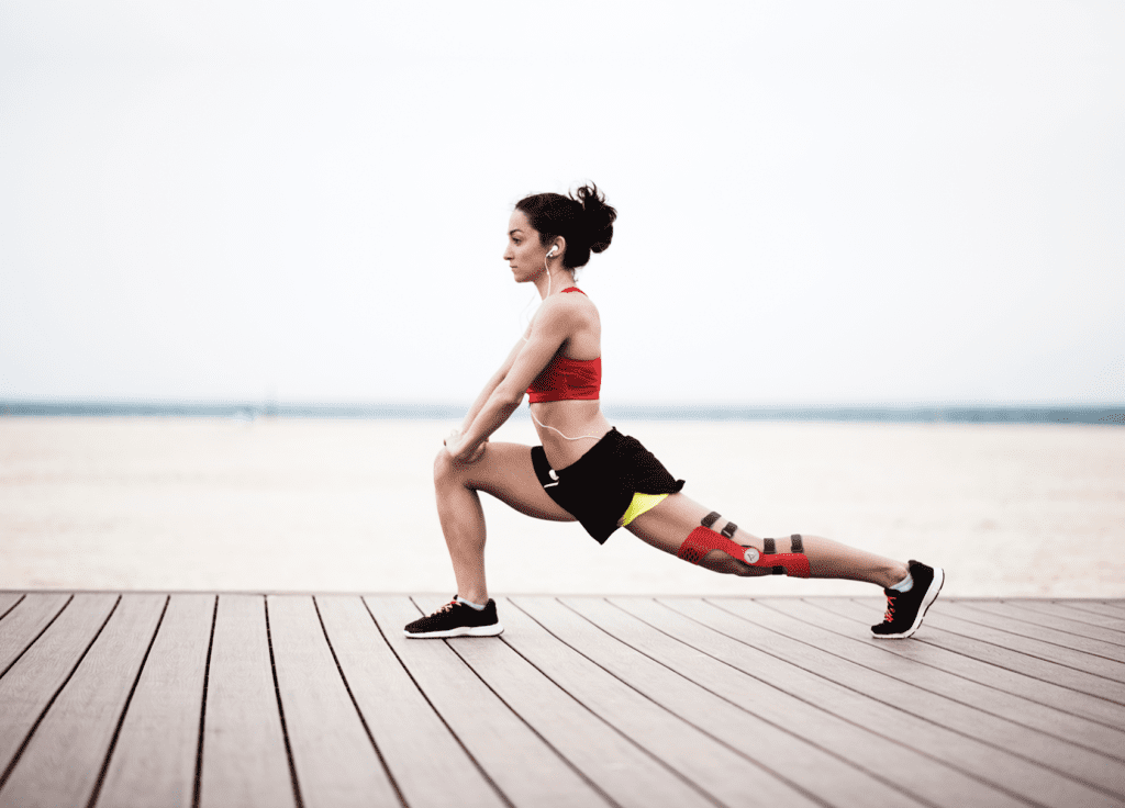 Woman stretching with a ligament knee brace